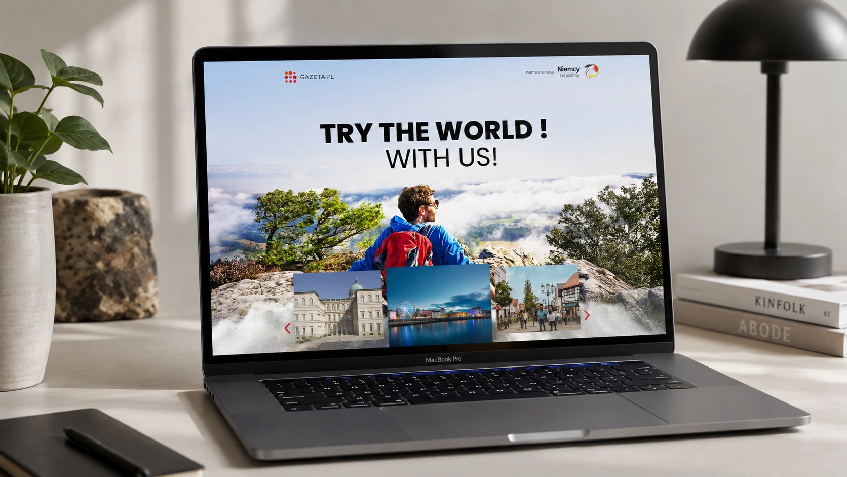 Makieta kampanii podróżniczej Gazeta.pl „Try the World with us!” na laptopie MacBook Pro; zdjęcie podróżnika spoglądającego na góry we mgle.